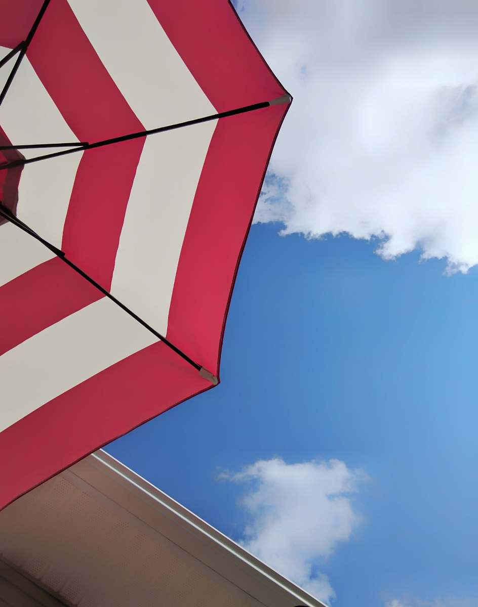 millhousen low angle photography of red and white umbrella blue